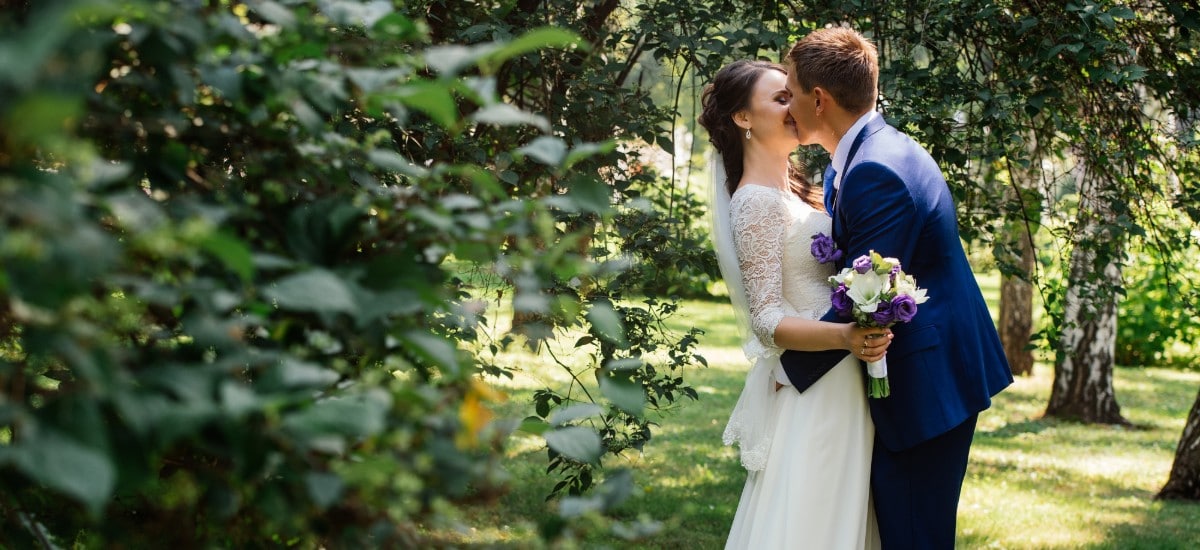 bride and groom kissing outside