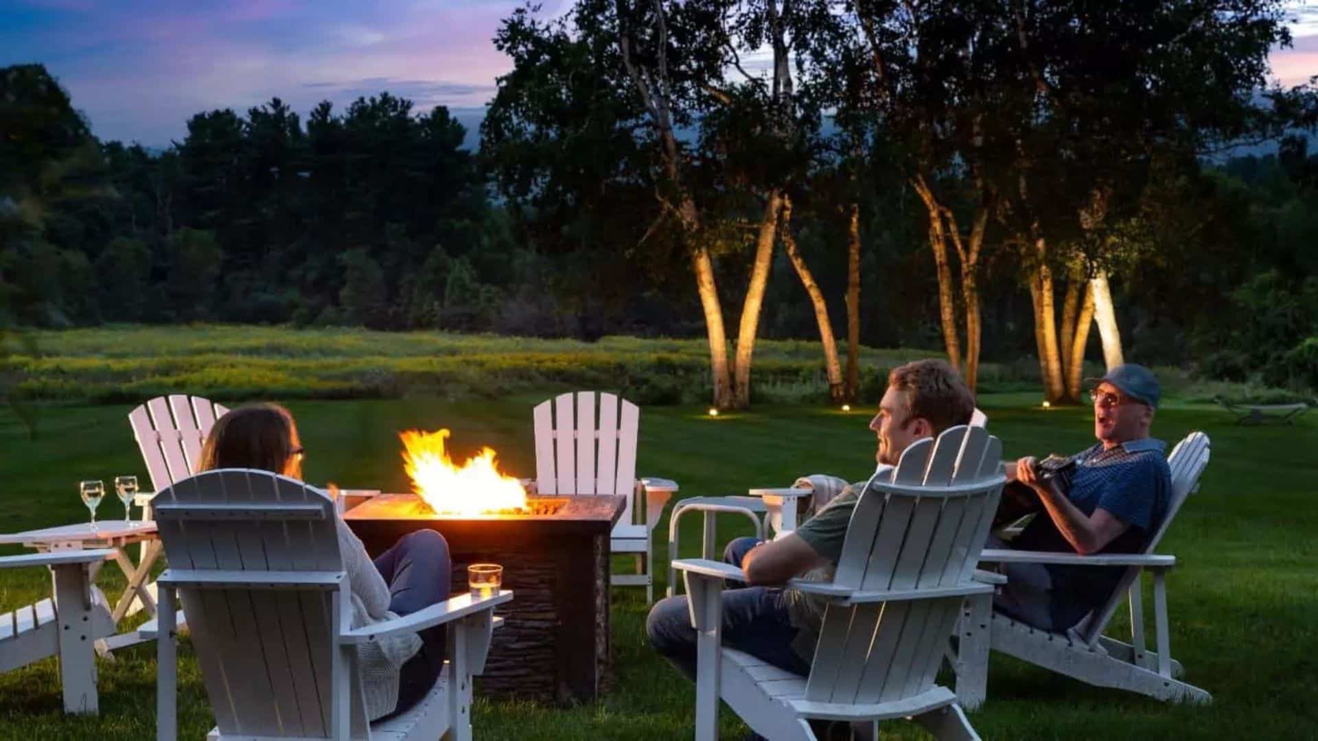 people around the firepit drinking wine and playing guitar at devonfield inn