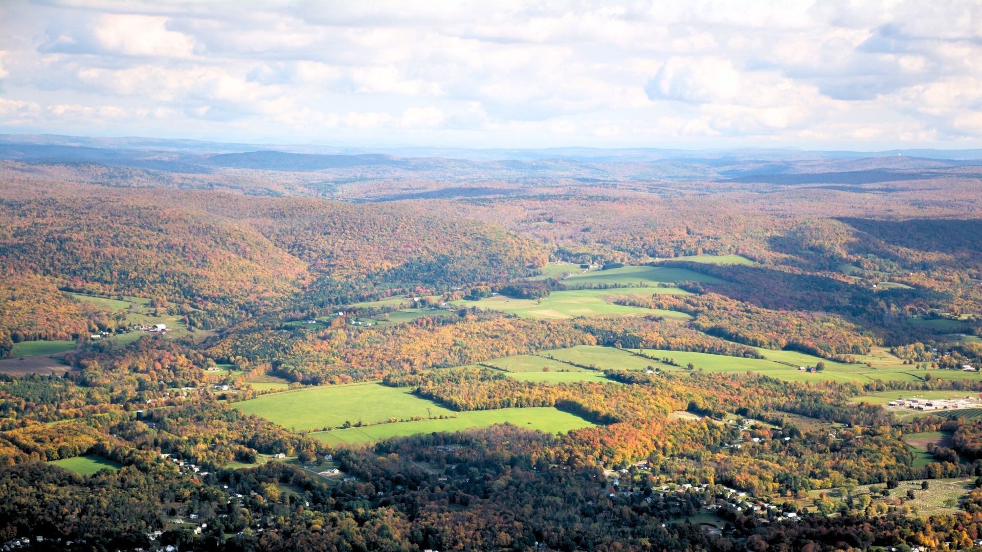 the view of the berkshires from mt. greylock in autumn. green fields and fall foliage.